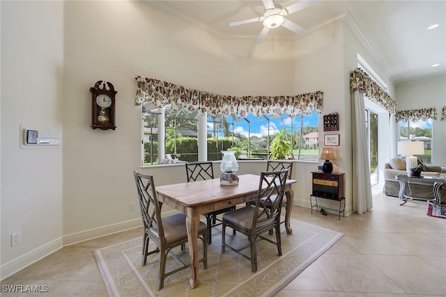 tiled dining room with ornamental molding and ceiling fan