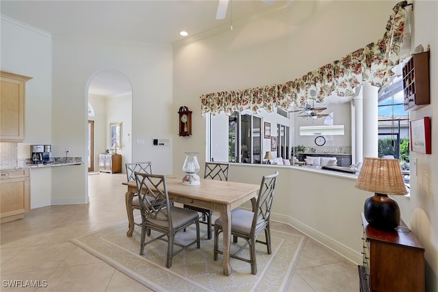 tiled dining area featuring ceiling fan and crown molding