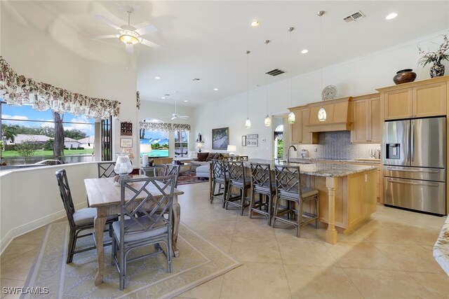 tiled dining area featuring ceiling fan, sink, and ornamental molding