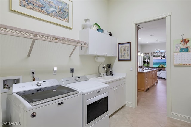 laundry room with light tile patterned floors, cabinets, sink, and independent washer and dryer