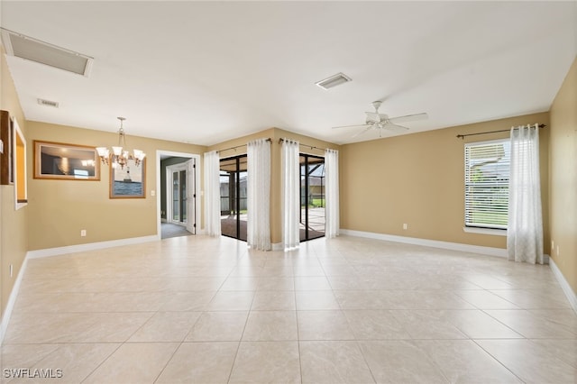 tiled spare room featuring ceiling fan with notable chandelier and plenty of natural light