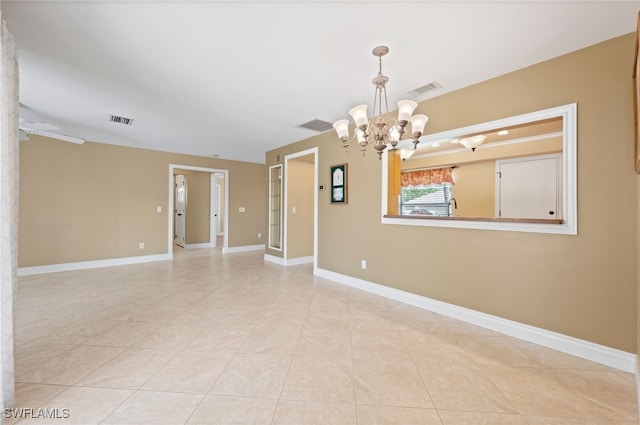 spare room featuring a notable chandelier and light tile patterned floors