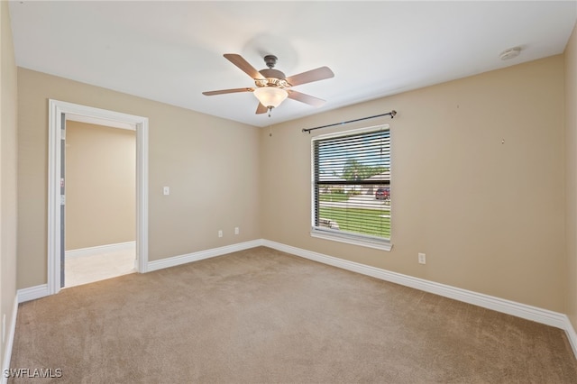 carpeted spare room featuring ceiling fan