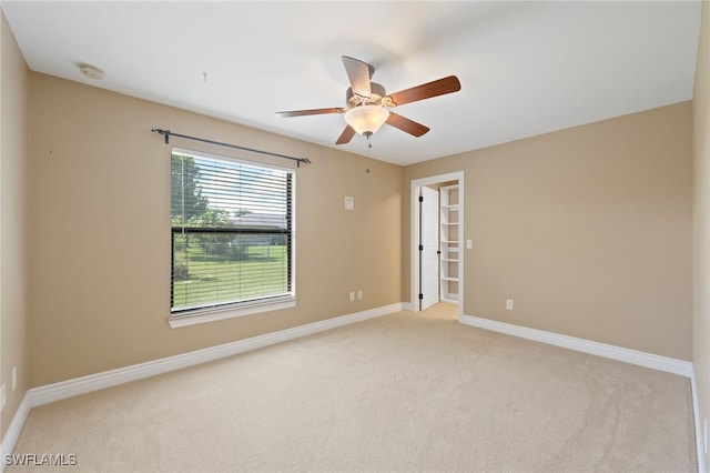 carpeted spare room featuring ceiling fan