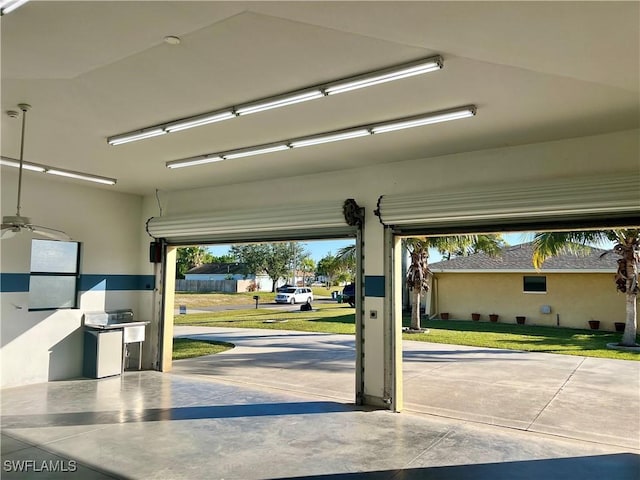 garage featuring a yard and ceiling fan