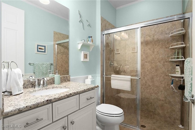 bathroom with vanity, toilet, an enclosed shower, and crown molding