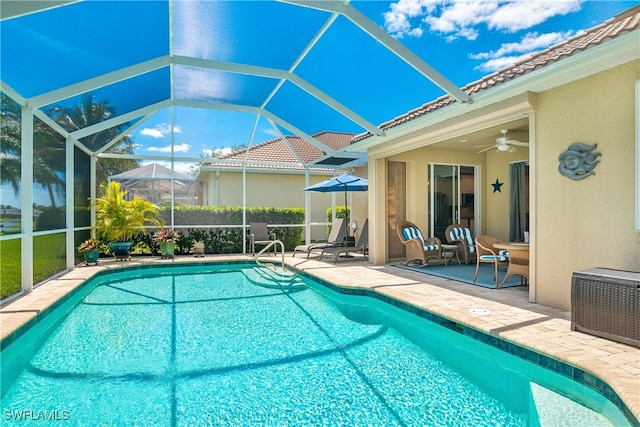 view of swimming pool with a patio, ceiling fan, and a lanai