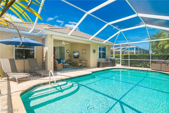 view of pool featuring ceiling fan, a patio area, glass enclosure, and grilling area