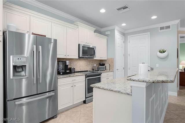 kitchen with white cabinetry, light stone countertops, stainless steel appliances, tasteful backsplash, and a kitchen island