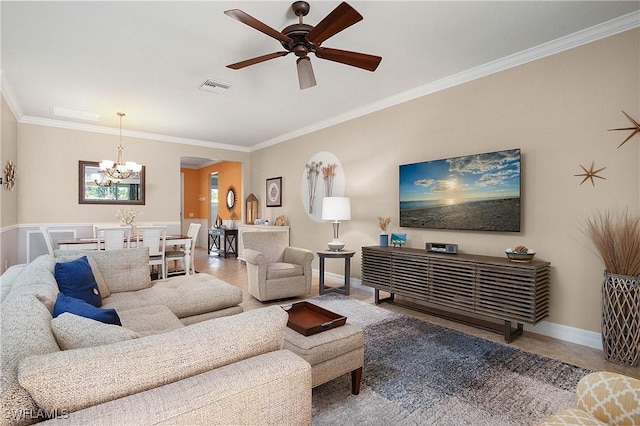 living room with ceiling fan with notable chandelier and ornamental molding