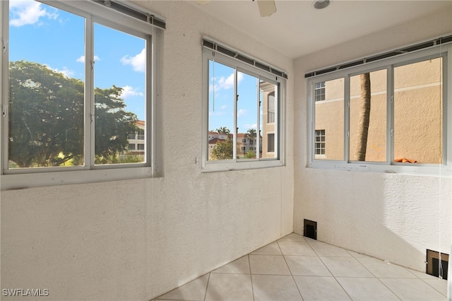 empty room featuring ceiling fan and light tile patterned flooring