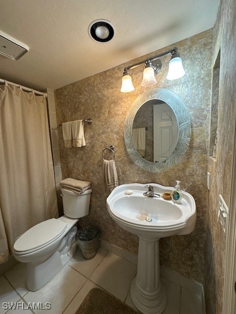 bathroom with a shower with curtain, sink, tile patterned flooring, and toilet