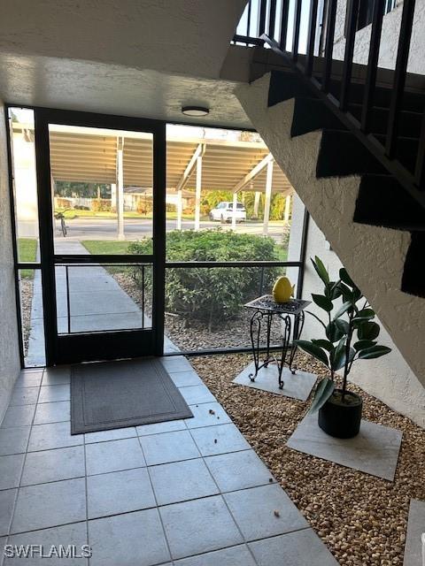 16679 Forest Blvd Unit 203, Fort Myers, FL 33908 - doorway with tile patterned floors and a wealth of natural light