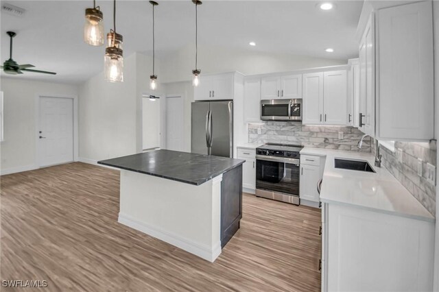 kitchen featuring sink, white cabinets, a center island, and stainless steel appliances