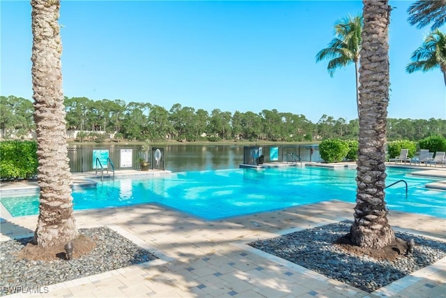 view of pool featuring a water view and a patio area