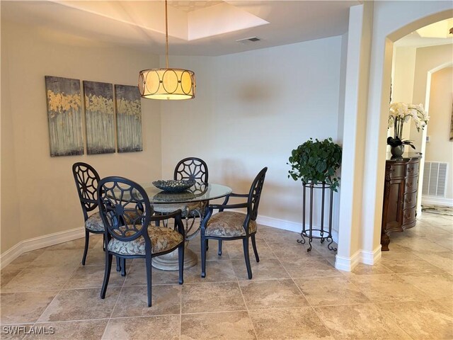 dining space featuring a raised ceiling