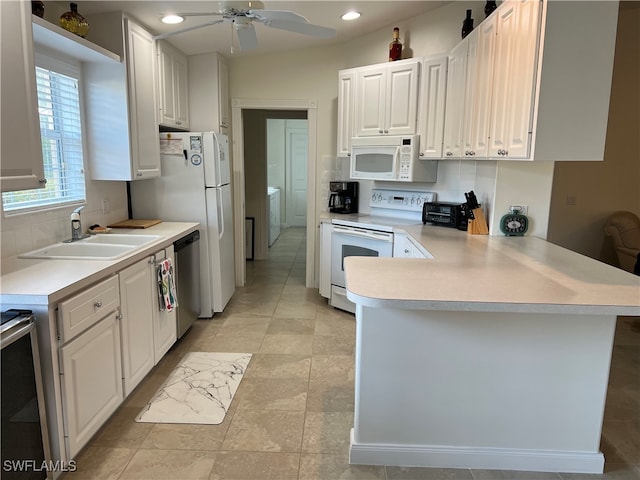 kitchen featuring white cabinets, appliances with stainless steel finishes, kitchen peninsula, and sink