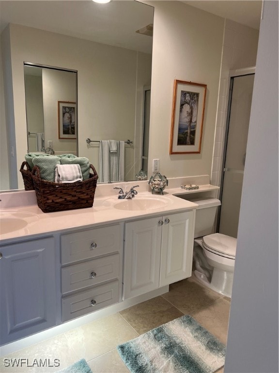 bathroom featuring tile patterned floors, toilet, vanity, and walk in shower