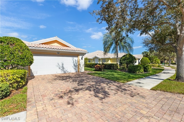 view of front of property with a garage and a front lawn