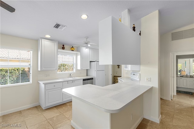 kitchen with ceiling fan, sink, kitchen peninsula, white appliances, and white cabinets