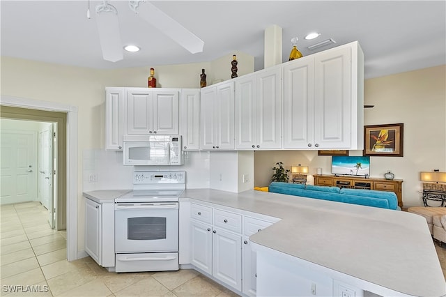 kitchen with white cabinets, light tile patterned floors, electric range oven, and kitchen peninsula