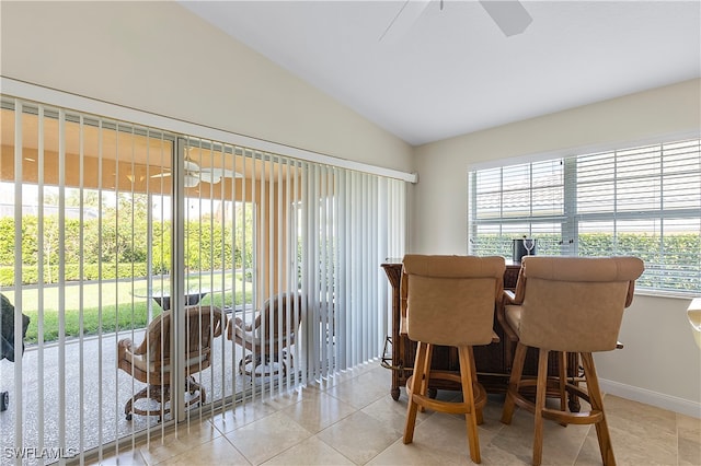 tiled dining room featuring indoor bar and vaulted ceiling