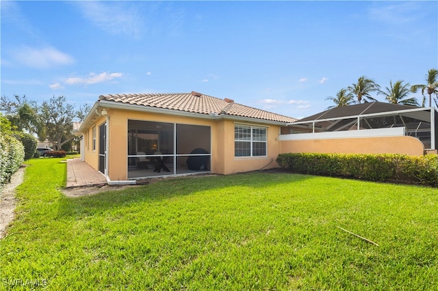 rear view of property with a yard and glass enclosure