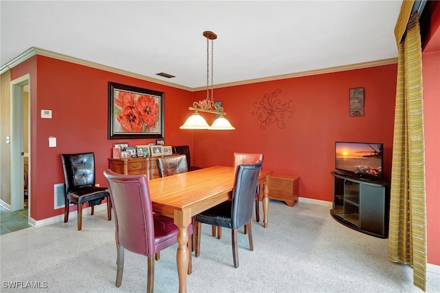 dining room featuring crown molding and carpet flooring