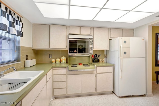 kitchen with decorative backsplash, white appliances, sink, and cream cabinetry