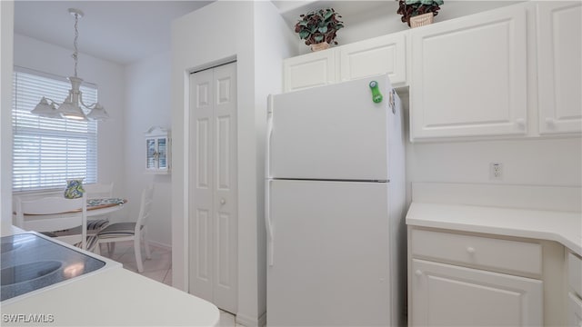 kitchen with white cabinetry, white refrigerator, and hanging light fixtures