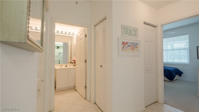 hallway featuring sink and light tile patterned floors