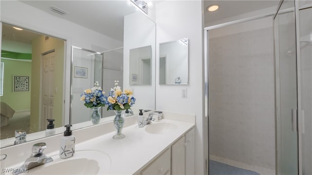 bathroom with a shower with shower door and vanity