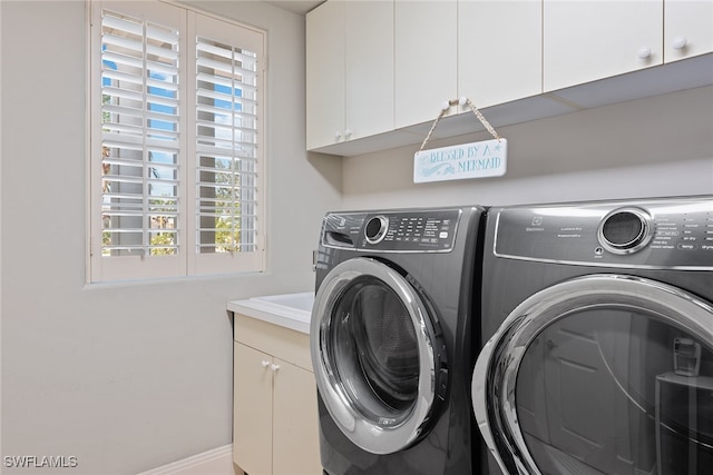 laundry area featuring separate washer and dryer and cabinets