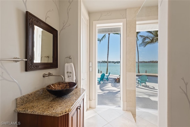 bathroom featuring a water view, vanity, and tile patterned flooring