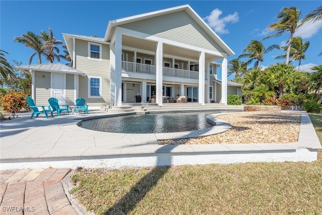 rear view of house featuring a balcony and a patio area