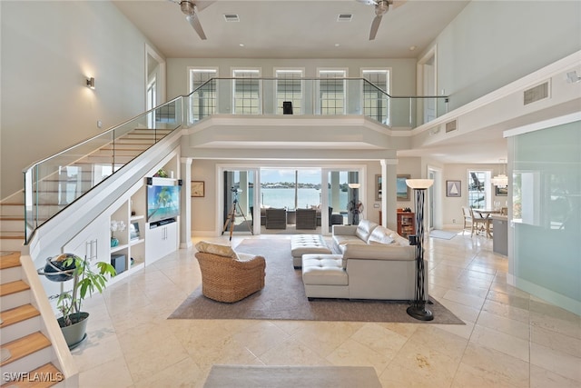 living room with a towering ceiling and ceiling fan