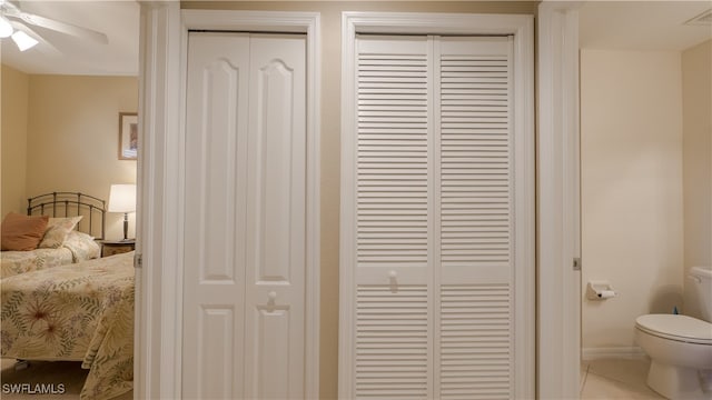 interior space with tile patterned flooring, toilet, and ceiling fan