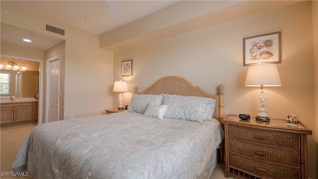 bedroom with light carpet, ensuite bath, and a closet