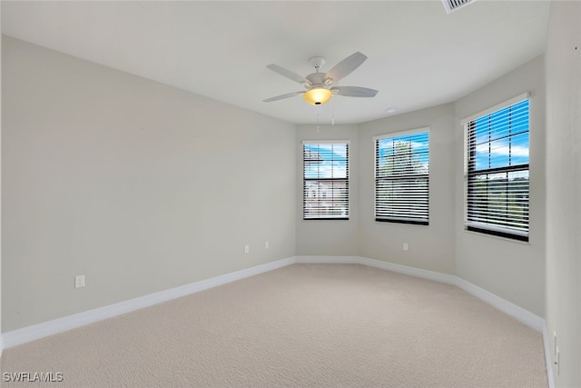 carpeted spare room featuring ceiling fan