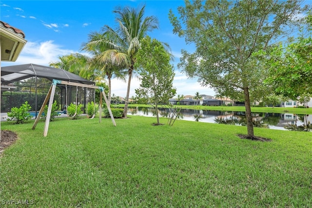 view of yard with glass enclosure and a water view