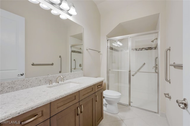 bathroom with vanity, tile patterned flooring, toilet, and a shower with door