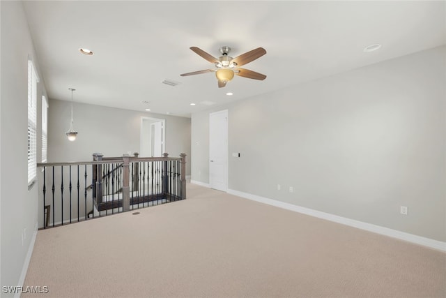 spare room with ceiling fan and carpet