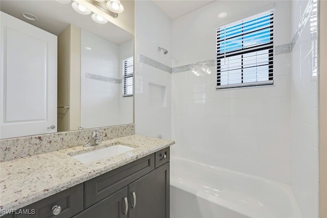 bathroom featuring tiled shower / bath combo and vanity