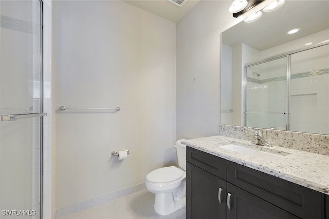 bathroom featuring vanity, toilet, a shower with door, and tile patterned floors