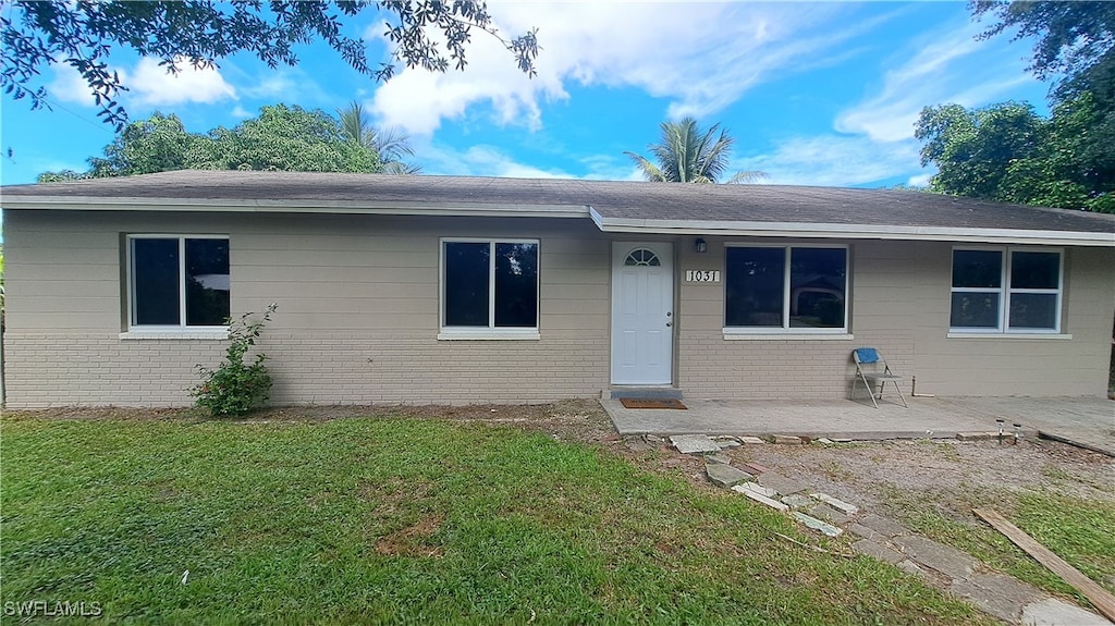 single story home with a front lawn and a patio area