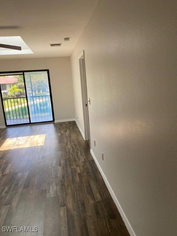 spare room with ceiling fan and dark wood-type flooring