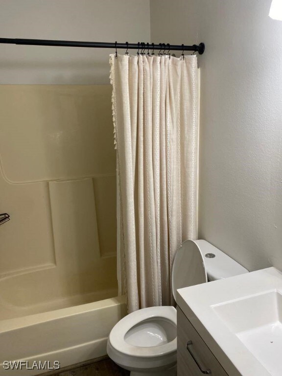 full bathroom with toilet, shower / bathtub combination with curtain, and sink