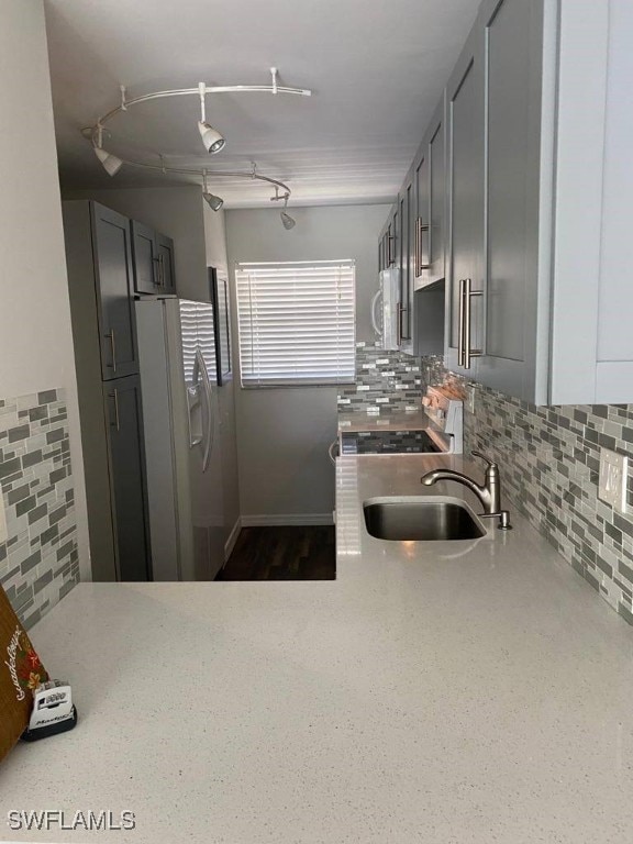 kitchen with gray cabinets, white appliances, sink, and tasteful backsplash