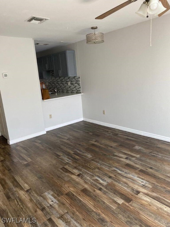 empty room with ceiling fan and dark hardwood / wood-style floors