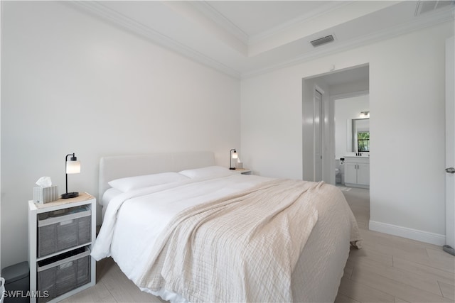 bedroom with ensuite bath and ornamental molding